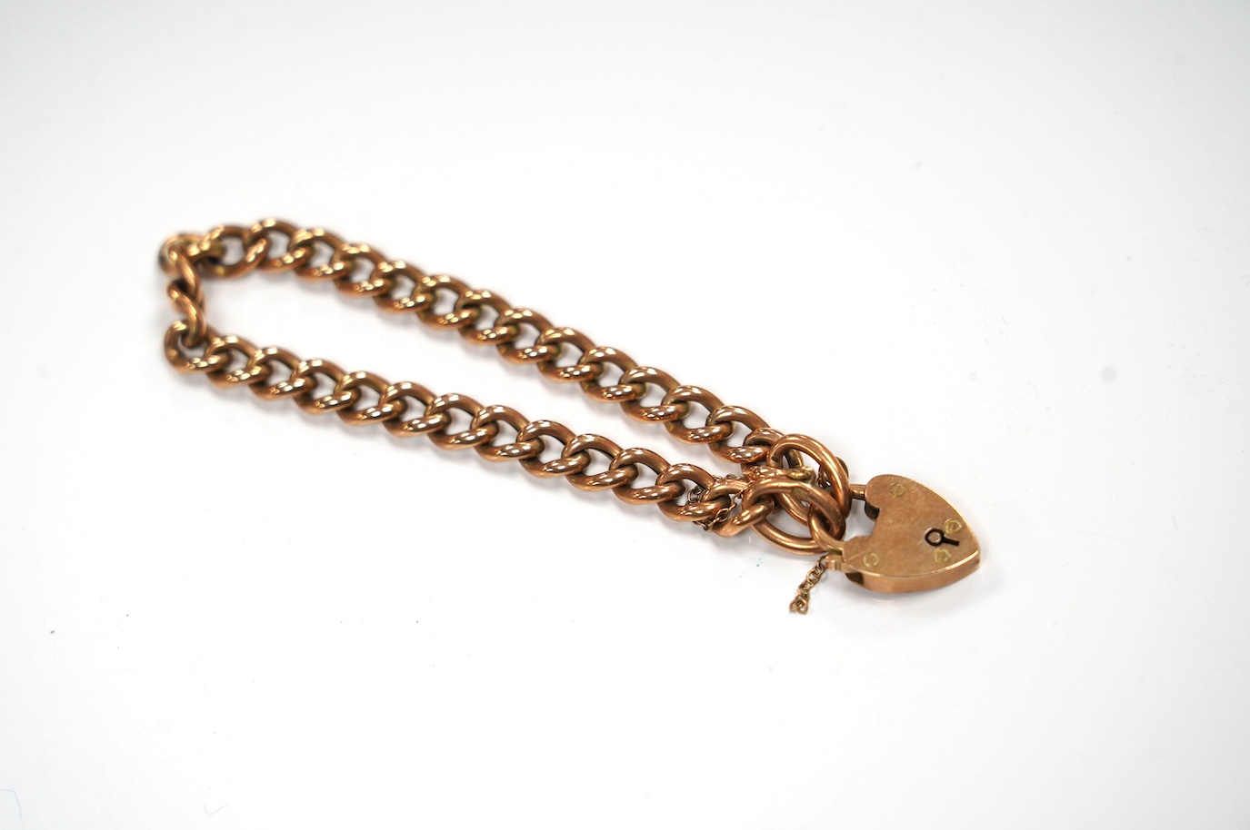 An Edwardian 9ct gold curb link bracelet, with heart shaped padlock clasp, 17cm, 10 grams. Condition - fair to good